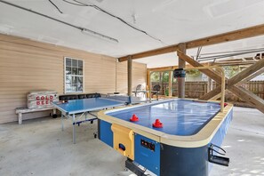 A ping pong table set up in a covered outdoor area with a wooden structure overhead. - Folly Fun House – Just Steps to the Beach (Folly Beach)