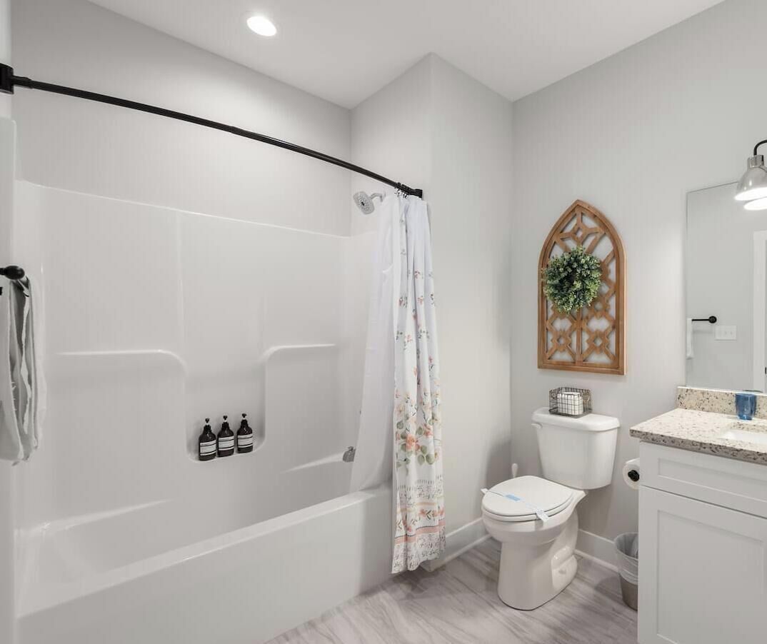 A bathroom with a bathtub, toilet, and vanity.