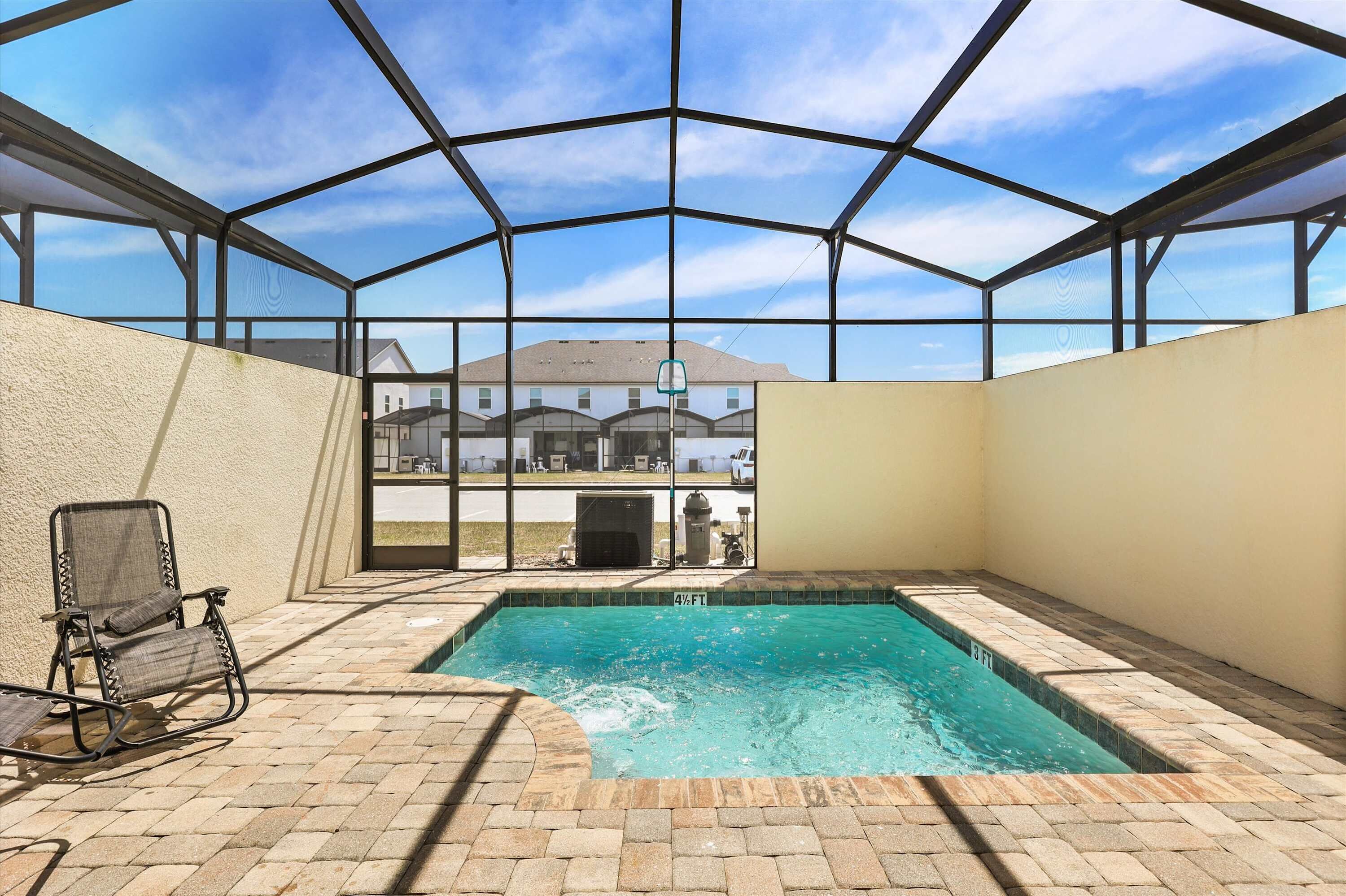 Piscina ao ar livre coberta com vista para casas ao fundo.