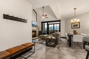 A modern living room with a fireplace, seating area, and dining space. - Crystal Peak Lodge 7404 ~ Ski-in/Ski-out ~ NEW LISTING ~ By CoralTree Residences (Breckenridge)