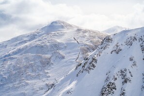 A snow-covered mountain with rocky outcrops and a clear sky. - Crystal Peak Lodge 7404 ~ Ski-in/Ski-out ~ NEW LISTING ~ By CoralTree Residences (Breckenridge)