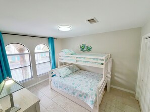 A child's bedroom with bunk beds, a window with curtains, and a wall decoration. - Emerald Palms Poolside | Community Pool • Steps to Navarre Beach • Pickleball Ct (Navarre)