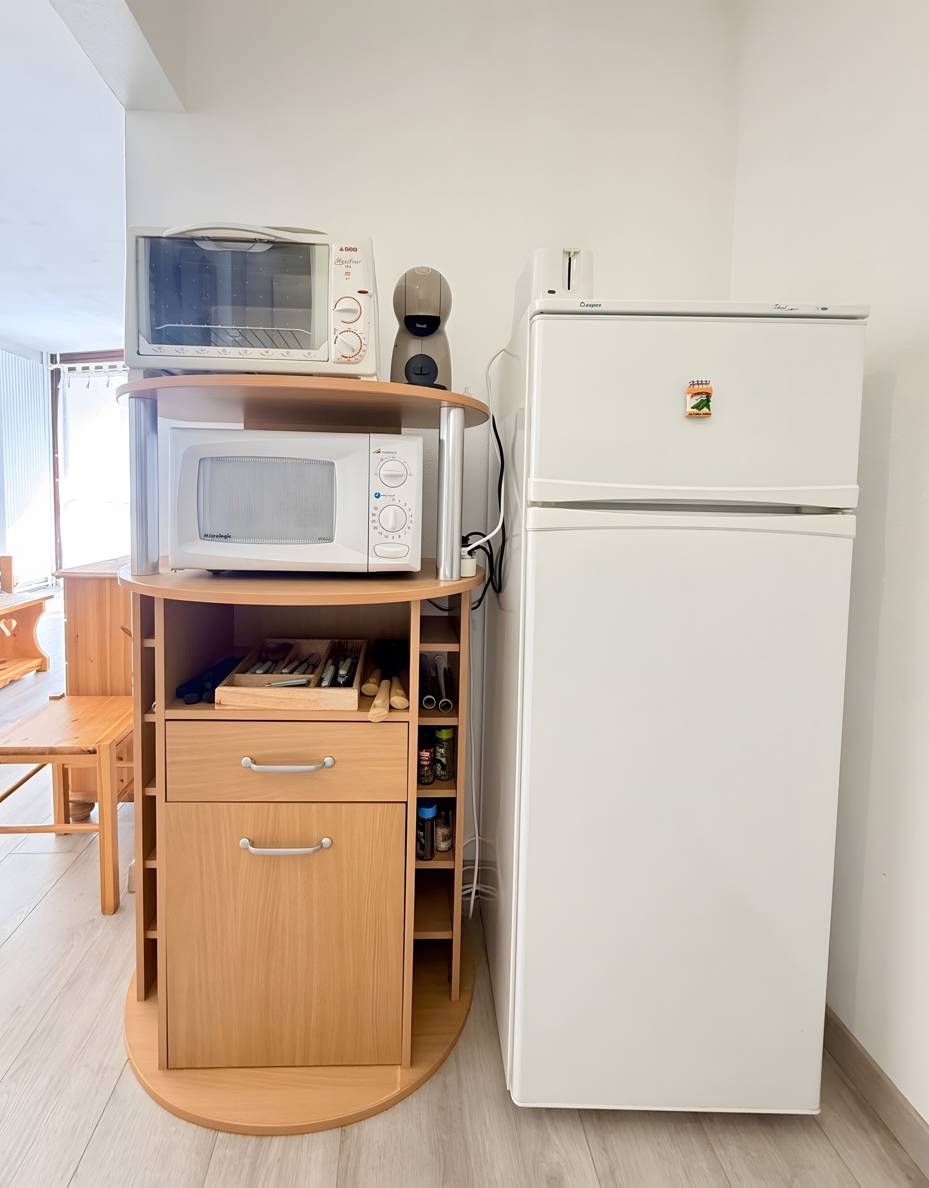Una cocina compacta equipada con microondas, tostadora y refrigerador.