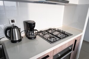 Eine Küche mit Gasherd, Kaffeemaschine und Wasserkocher.