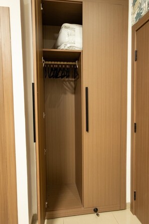 A wooden wardrobe with a hanging space and a small shelf. - Cozy & Bright 2-Room Apartment in Dakar (Dakar)