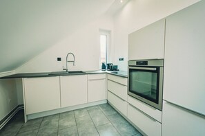 Eine moderne Küche mit Backofen, Spüle und Fenster.