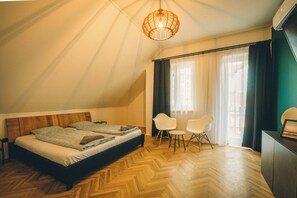 A bedroom with a bed, two chairs, a table, a hanging light fixture, and a window with curtains. - Modern 4-bedroom vacation rental with a garden in Siófok; dog-friendly (Siófok)