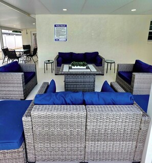 A poolside lounge area with wicker furniture and a sign detailing pool rules. - Family Pool Retreat - Sleeps 8 - Pet Friendly (Tampa)