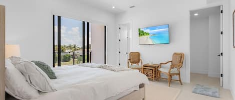 Un dormitorio con una cama grande, un televisor y vistas al exterior.