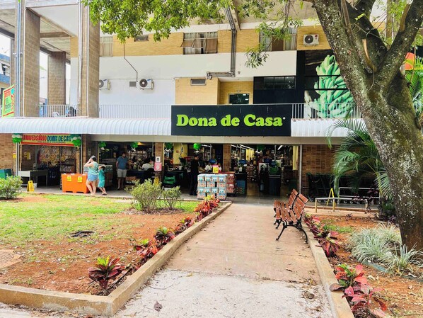 Ein Schaufenster mit dem Namen 'Dona de Casa', ein sichtbarer Eingang, eine kleine Außenbestuhlung und ein Weg zum Eingang.