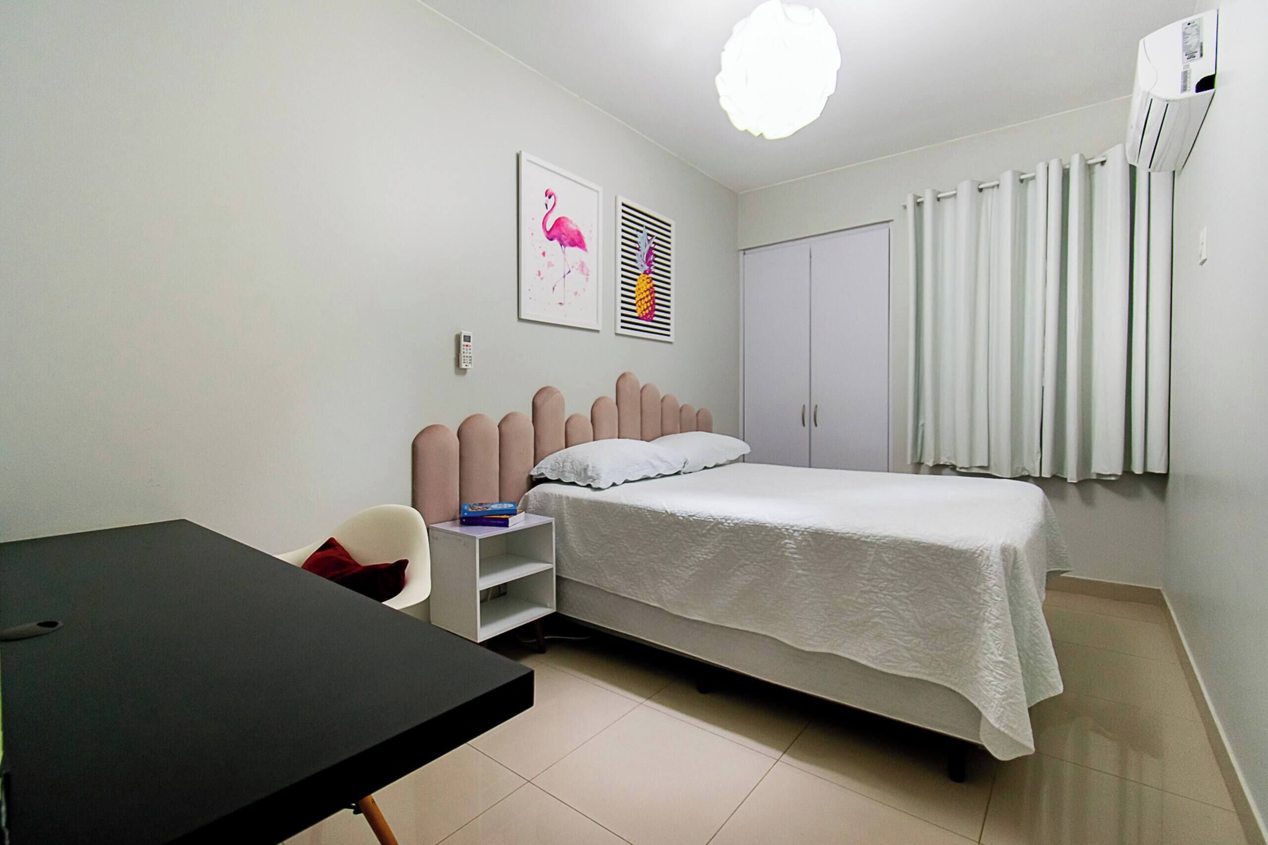 Una camera da letto con un letto, una scrivania, una sedia, un armadio e una finestra con tende.