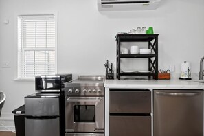 A modern kitchen with a built-in oven, microwave, and dishwasher. - Augusta Carriage House Cozy Retreat w Kitchen (Augusta)