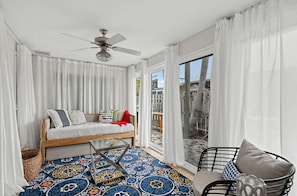 A room with a bed, a chair, a ceiling fan, and a large window. - Coastal Naples Park Getaway - Garden Grill Beach Nearby (Naples)