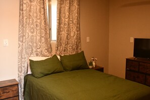 A bedroom with a bed, curtains, a television, and a dresser. - This spacious home is right off hwy 70 in Pima, perfect for your travel needs. (Pima)