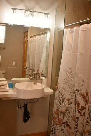A bathroom with a sink, mirror, and shower curtain. - This spacious home is right off hwy 70 in Pima, perfect for your travel needs. (Pima)