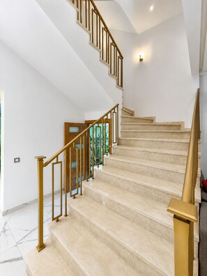 A modern staircase with a wooden handrail and beige steps. - PREMIUM EXPERIENCE - MODERN VILLA WITH EXCEPTIONAL COMFORT (مراكش)