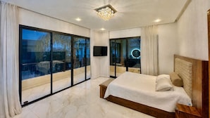 A bedroom with a large bed, sliding glass doors, a flat-screen TV, and a chandelier. - PREMIUM EXPERIENCE - MODERN VILLA WITH EXCEPTIONAL COMFORT (مراكش)
