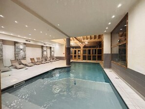 An indoor swimming pool with lounge chairs and a stone wall. - 150m from ski slopes, 2nd floor, balcony, tv, ski locker, 47m², Montchavin La Plagne (Bellentre)