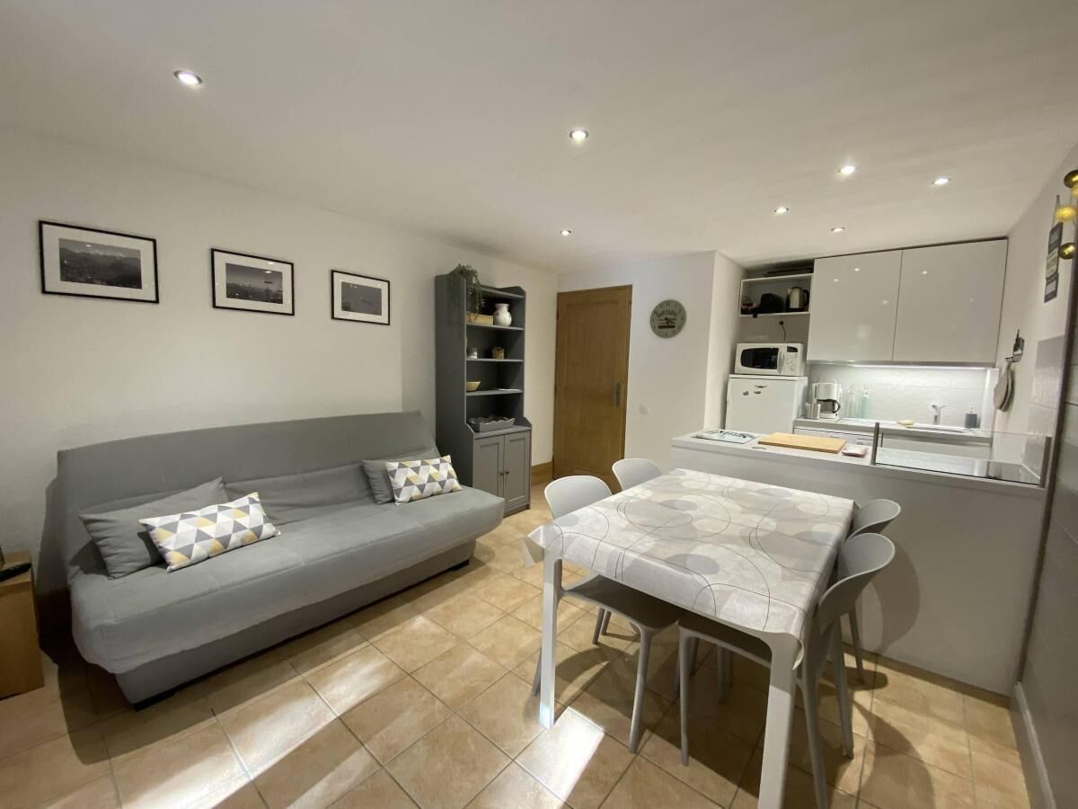 Un espace de vie compact comprenant un canapé, une table à manger et une kitchenette.