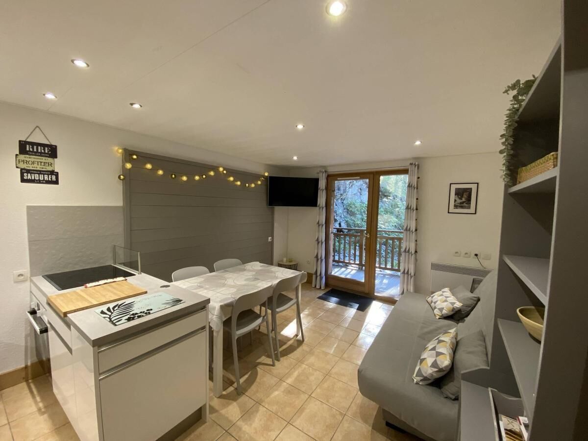 A compact living space with a kitchenette, dining area, and a balcony.