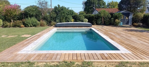 A rectangular swimming pool with a wooden deck surrounding it. - Holiday Home “La Maison de Pascale” with Private Pool, Wi-Fi & Air Conditioning (Orist)