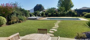 A backyard with a swimming pool, a wooden deck, and a lawn. - Holiday Home “La Maison de Pascale” with Private Pool, Wi-Fi & Air Conditioning (Orist)