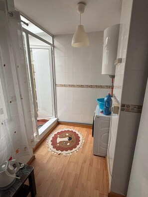 A kitchen with a window, a washing machine, and a patterned rug. - Beach Apartment 100m from the Sea - A/C, Garage &Terrace (San Pedro del Pinatar)