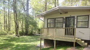 A single-story cabin with a wooden deck and a small porch. - Quiet 2-bedroom house in fantastic Fairburn with cool AC. (Fairburn)