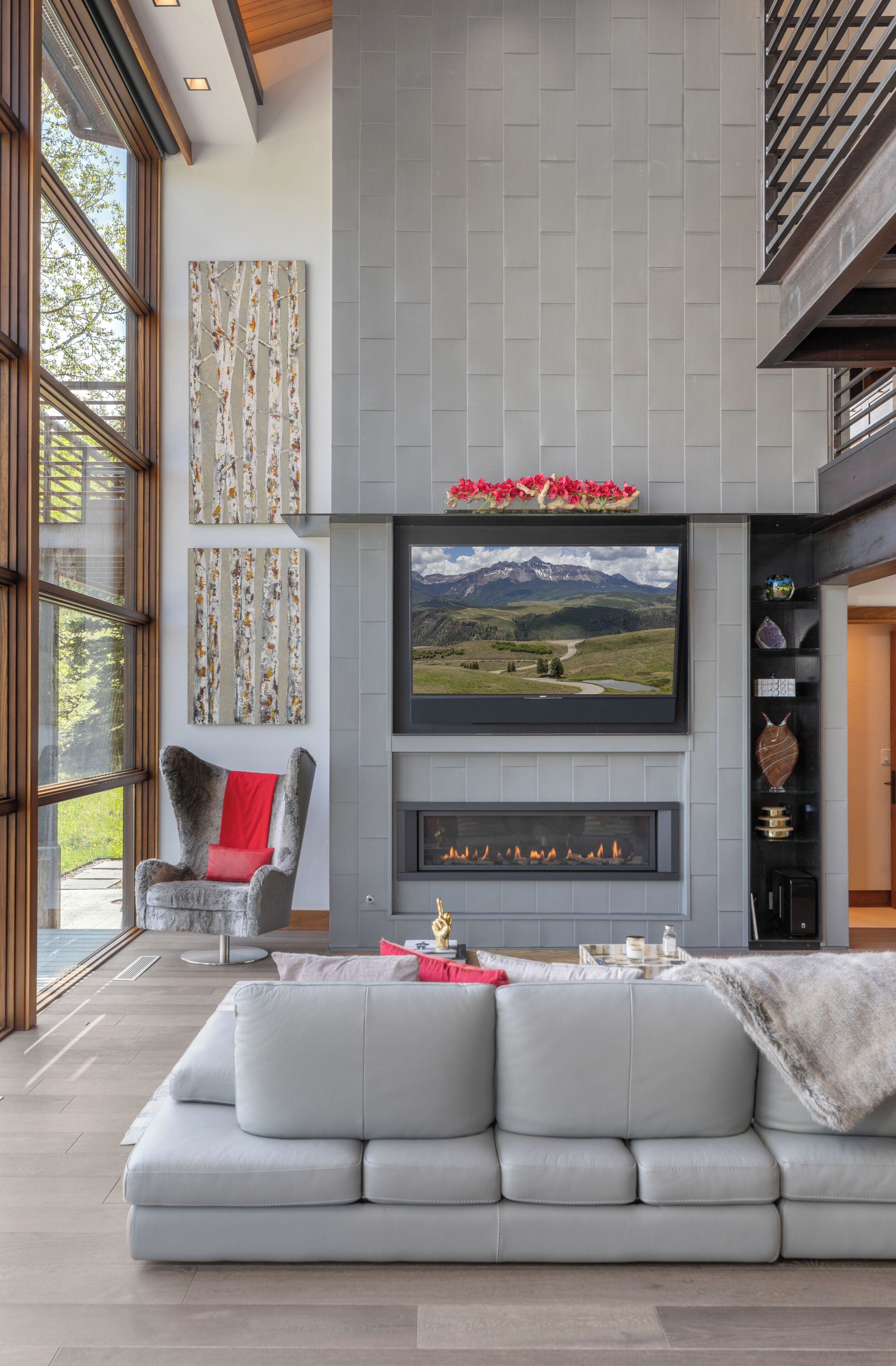 A modern living room with a fireplace, a large flat-screen TV, and a stone fireplace surround.