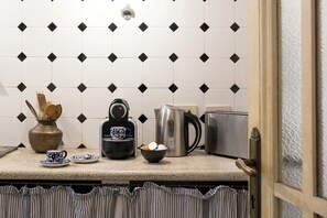 A kitchen counter with a coffee maker, kettle, and toaster. - Colosseo The Family Home in Monti (Roma)