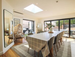 A dining area with a long table, chairs, a large mirror, and a view of the outdoors. - The Lodge (Shrewsbury)