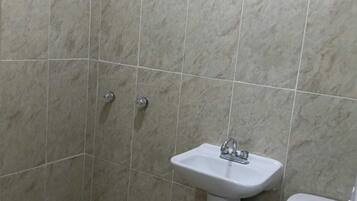 Een badkamer met een douche, wastafel en toilet.