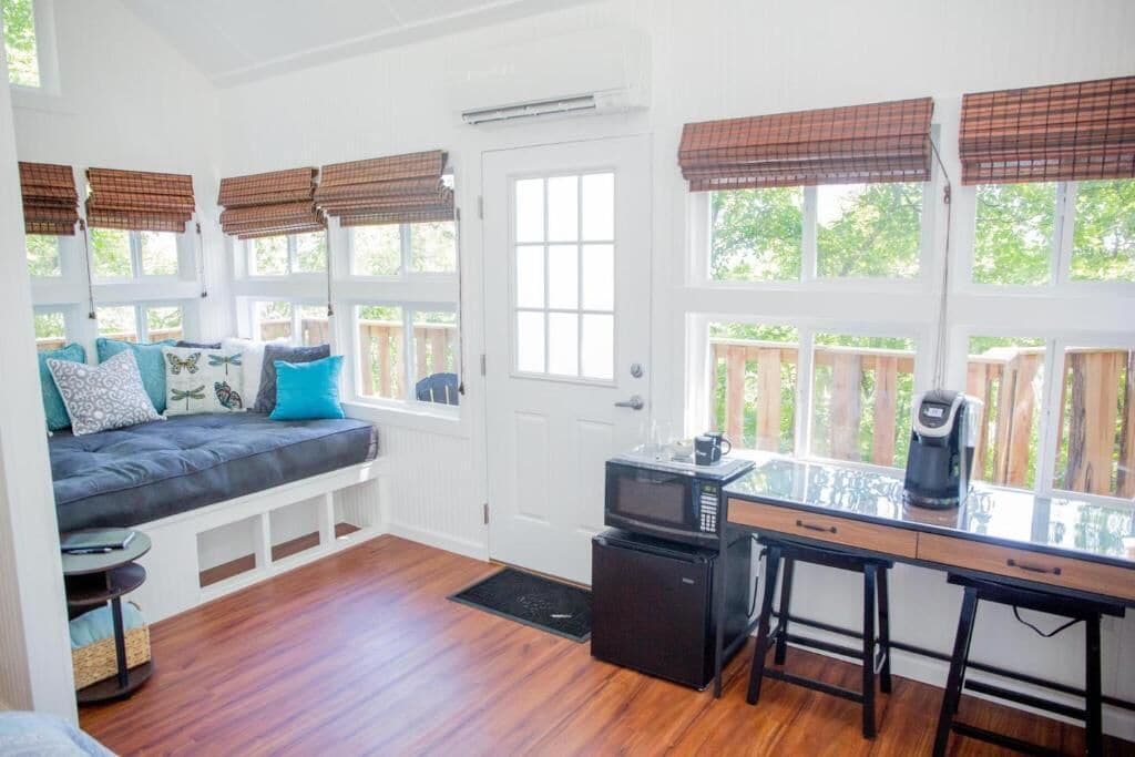 A cozy room with a sofa, a coffee maker, and a microwave.
