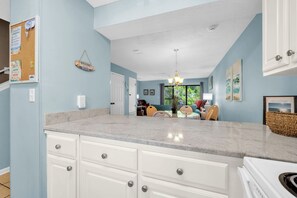 A kitchen with white cabinets and a marble countertop. - New Listing! Master Balcony* 3 Pools* Walk to Sand (Panama City Beach)