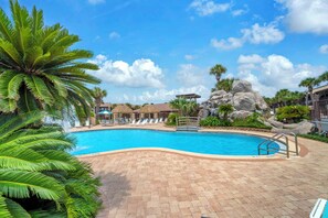 A swimming pool with a no diving sign, lounge chairs, palm trees, and a rock formation. - New Listing! Master Balcony* 3 Pools* Walk to Sand (Panama City Beach)