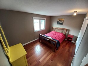A bedroom with a wooden bed, a window, and a yellow chair. - Private Room - Opposite Hospital and Uni (Calgary)