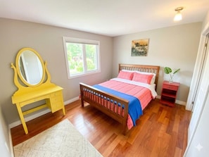 A bedroom with a wooden bed, a yellow vanity with a mirror, a window, and a small red shelf. - Private Room - Opposite Hospital and Uni (Calgary)