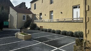 Un edificio con un cortile lastricato, una scala e un ingresso sorvegliato.