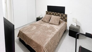 Ein Schlafzimmer mit einem Bett, Nachttischen, einem Fernseher und einem pinken Trainingsball.