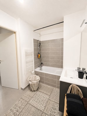 A modern bathroom with a bathtub, a sink, and a shower area. - New apartment, terrace & parking – Résidence Boréal, Montpellier (Monptellier)