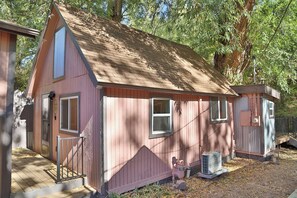 Ein kleines, eingeschossiges Haus mit Satteldach, einer Veranda und einer kleinen angebauten Garage.