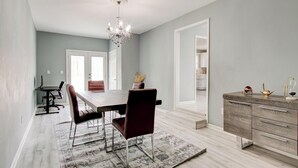 A dining area with a table, chairs, a chandelier, and a rug. - Luxury, Romantic, Unique Retreat (Norcross)