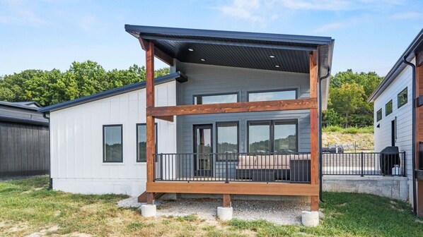 A modern two-story building with a balcony, large windows, and a flat roof.