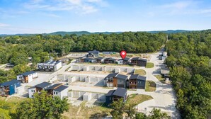 A residential area with modern houses, a main road, and a red location marker. - Luxury Getaway | Lake View + Fire Table (Reeds Spring)