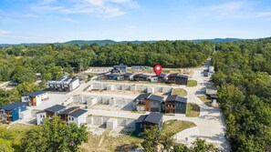 A residential area with modern houses, a main road, and a red location marker. - Luxury Getaway | Lake View + Fire Table (Reeds Spring)