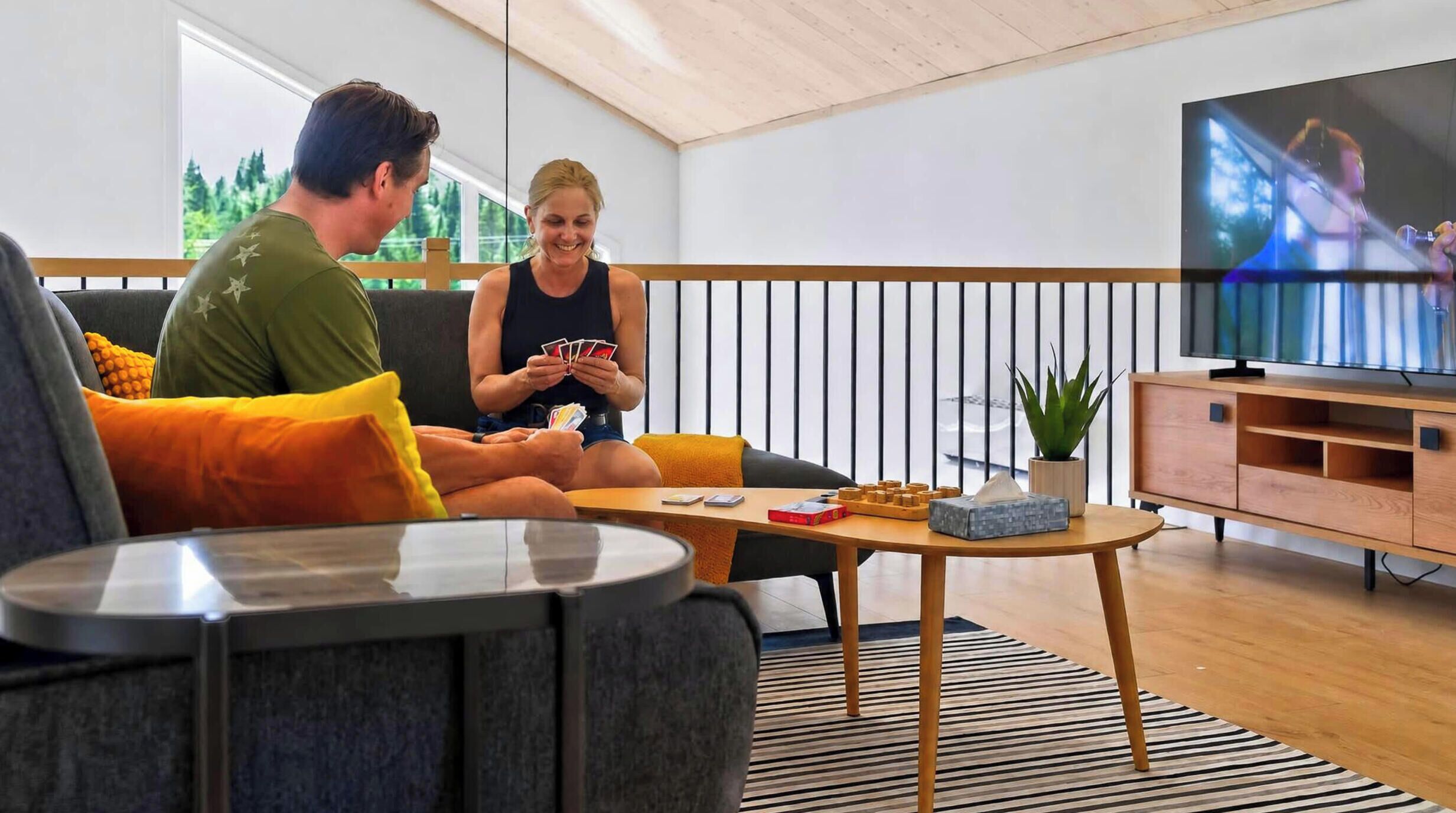 A modern living room with a sofa, a coffee table, and a television.