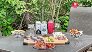 A table set outdoors with food, drinks, and condiments. - The Enlightened - Retreat Under the Megantic Stars (Notre-Dame-des-Bois)