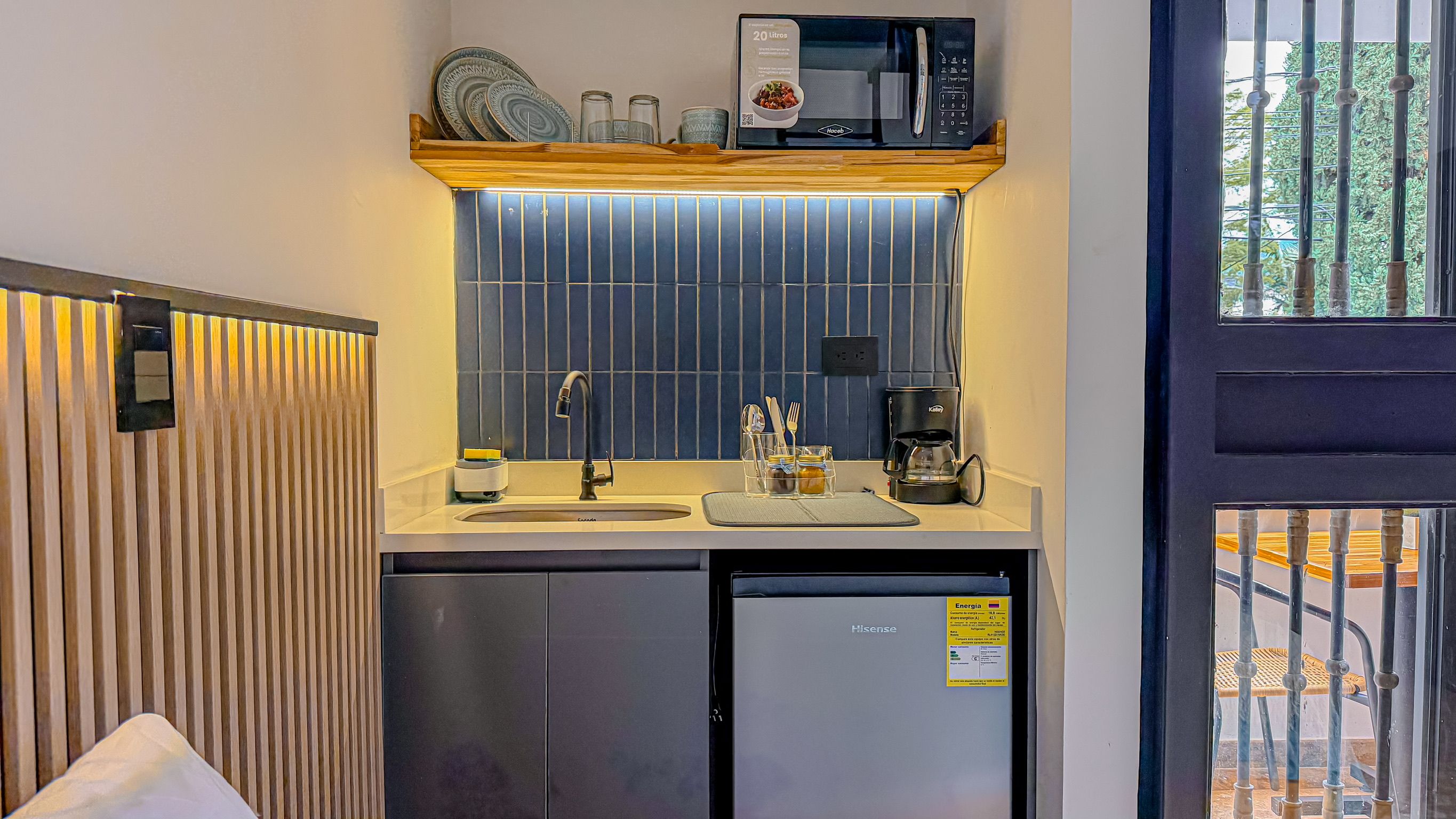 A compact kitchenette with a microwave, coffee maker, and a small refrigerator.