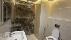 Une salle de bain moderne avec une douche à parois de verre, un lavabo blanc et des toilettes.