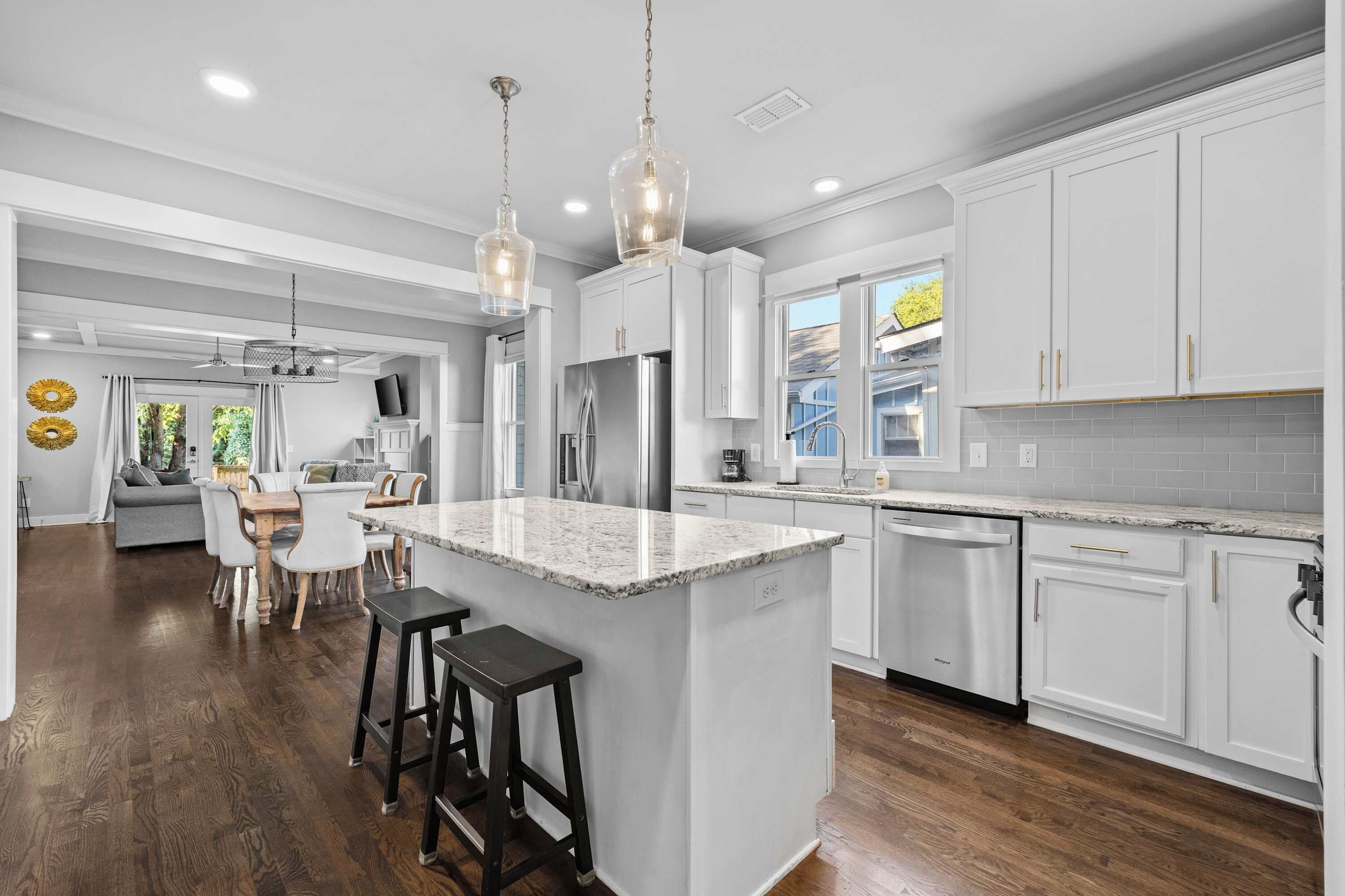 A modern kitchen with white cabinetry, a central island, and stainless steel appliances.